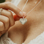 Woman wearing a silver heart shaped breastmilk filled pendant