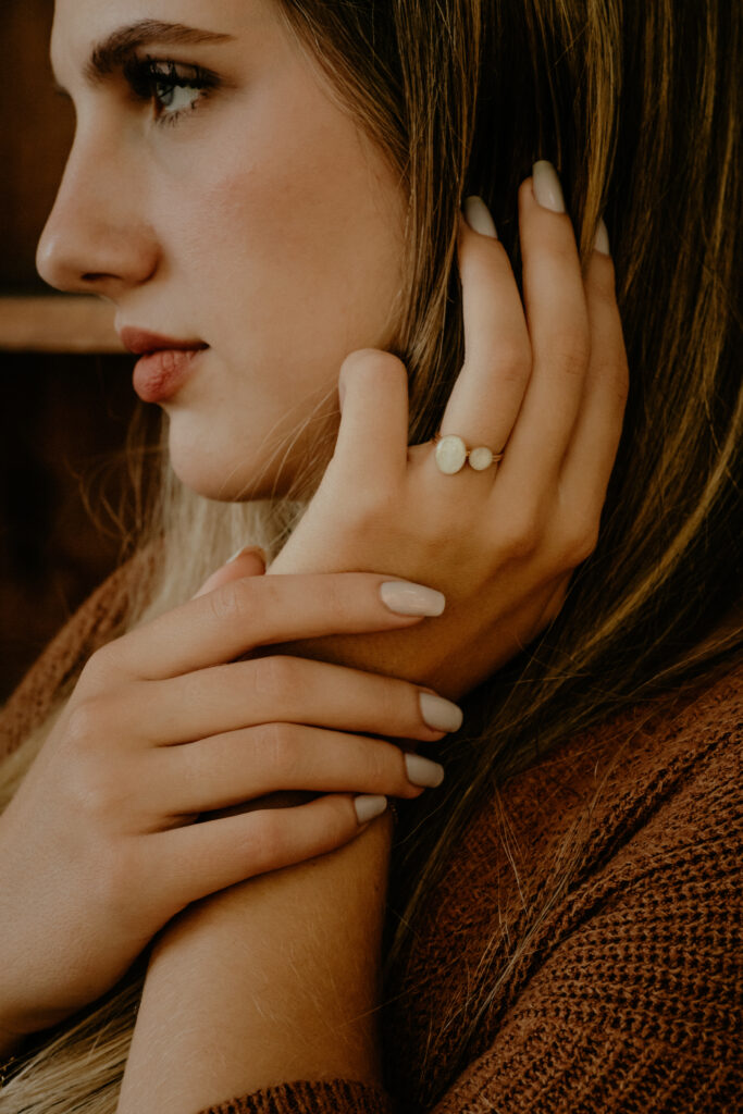 Woman wearing a gold double oval breastmilk filled ring