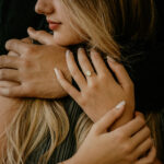 Woman wearing gold oval breastmilk filled ring