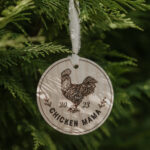 Wooden Christmas ornament with laser engraved chicken hanging on a tree