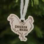 Wooden Christmas ornament with laser engraved chicken hanging on a tree