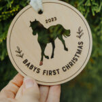 Wooden Christmas ornament with laser engraved horse hanging on a tree