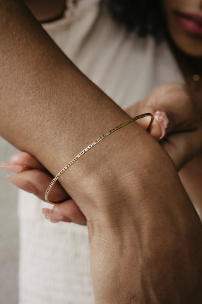 Close-up of a gold cuff bracelet on a woman's wrist.